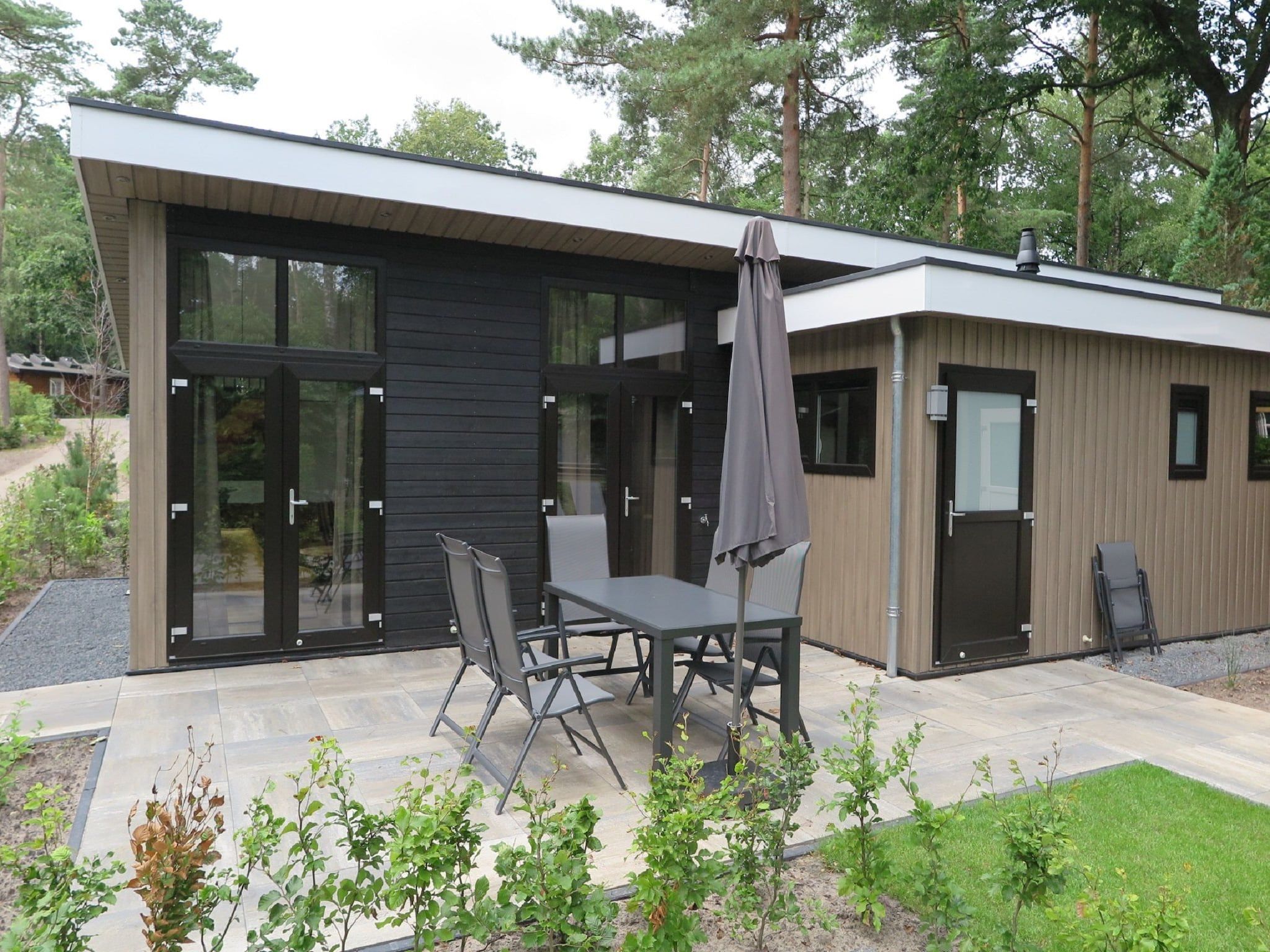 Het terras van Vakantiepark De Rimboe & De Woeste Hoogte 25 in Hoenderloo