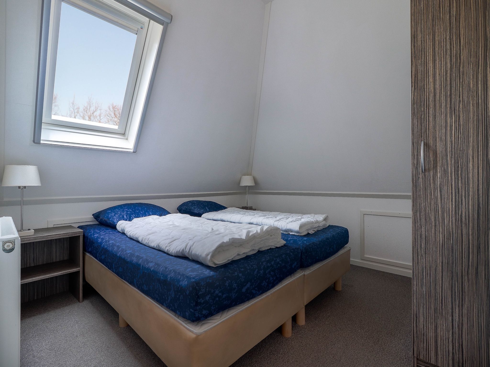 Een slaapkamer van Beachvilla Royaal met Sauna - 10 personen in Makkum