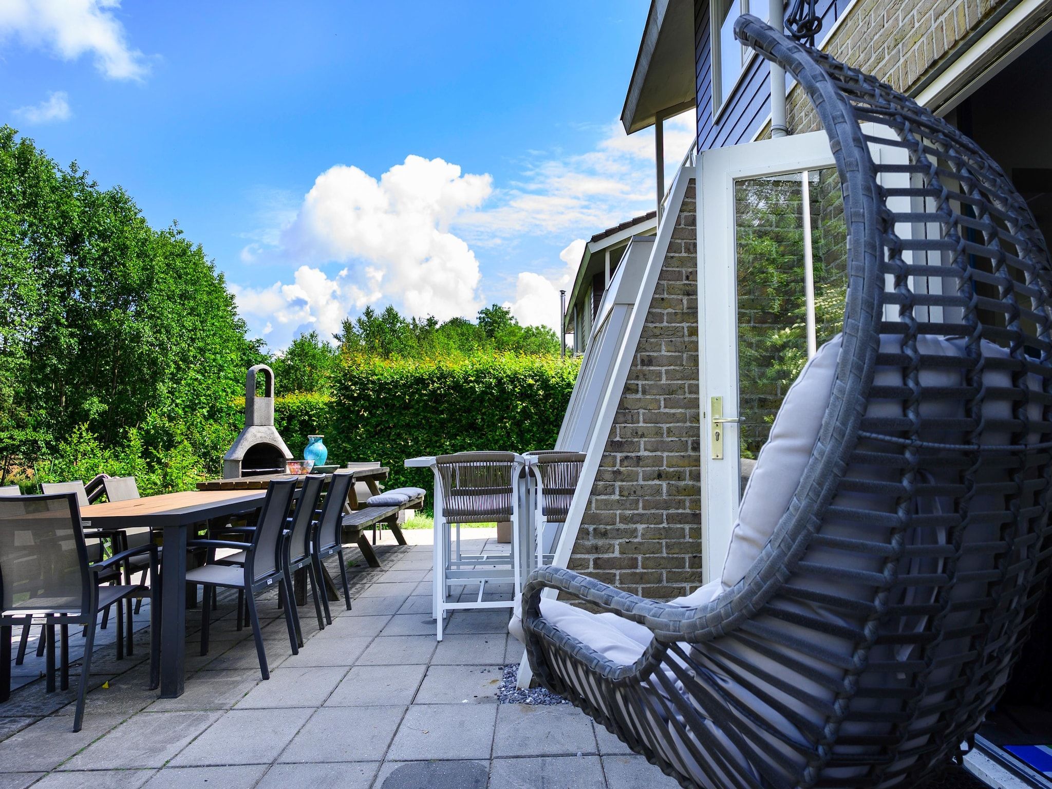 Het terras van 18 pers Ellersinghuis wellness met houtgestookte hottub in Vlagtwedde