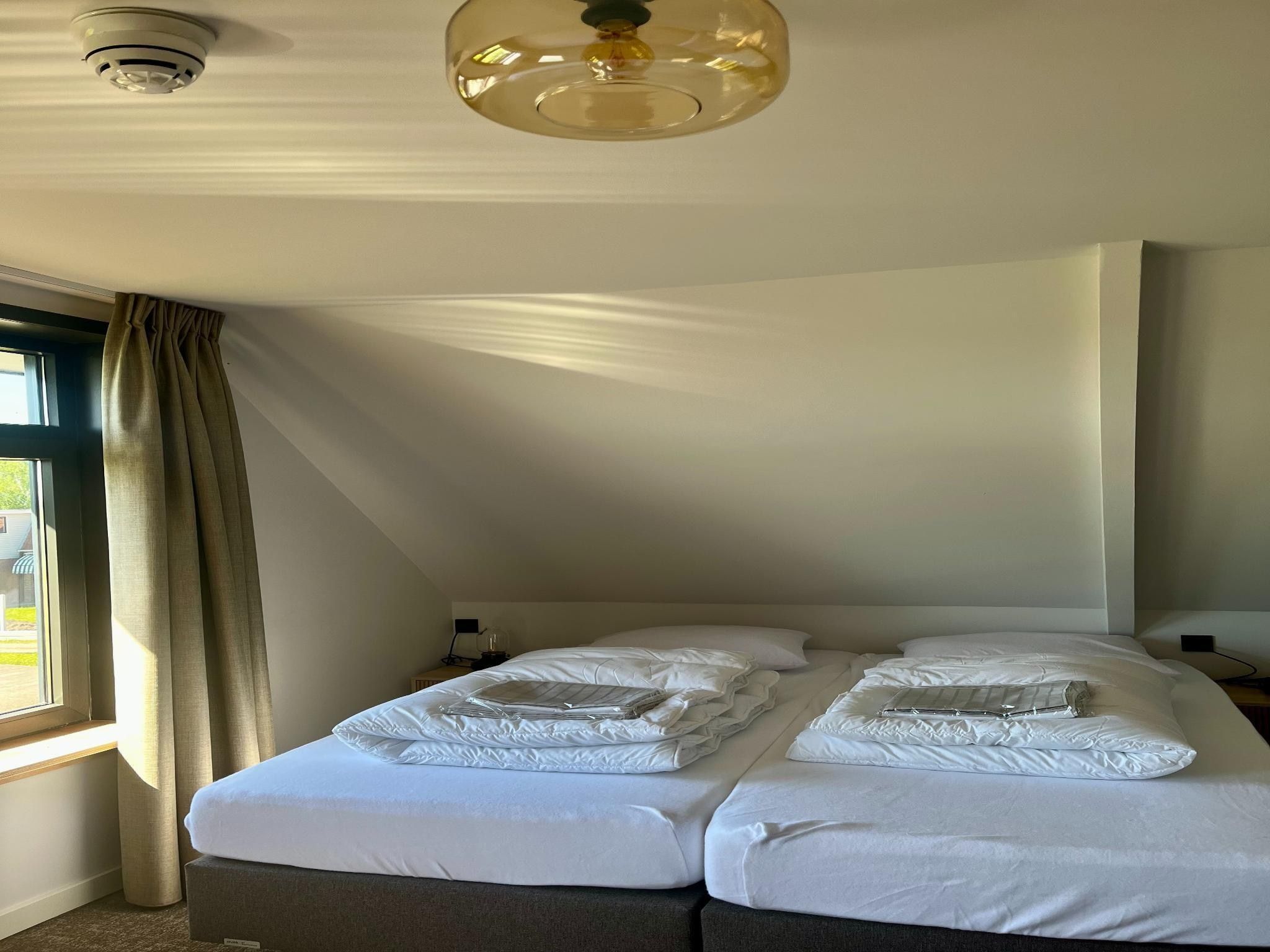 Een slaapkamer van Groepsaccommodatie voor 20 personen + 5 Tiny Greenhouses voor 2 tot 4 personen in Scherpenzeel (FR)