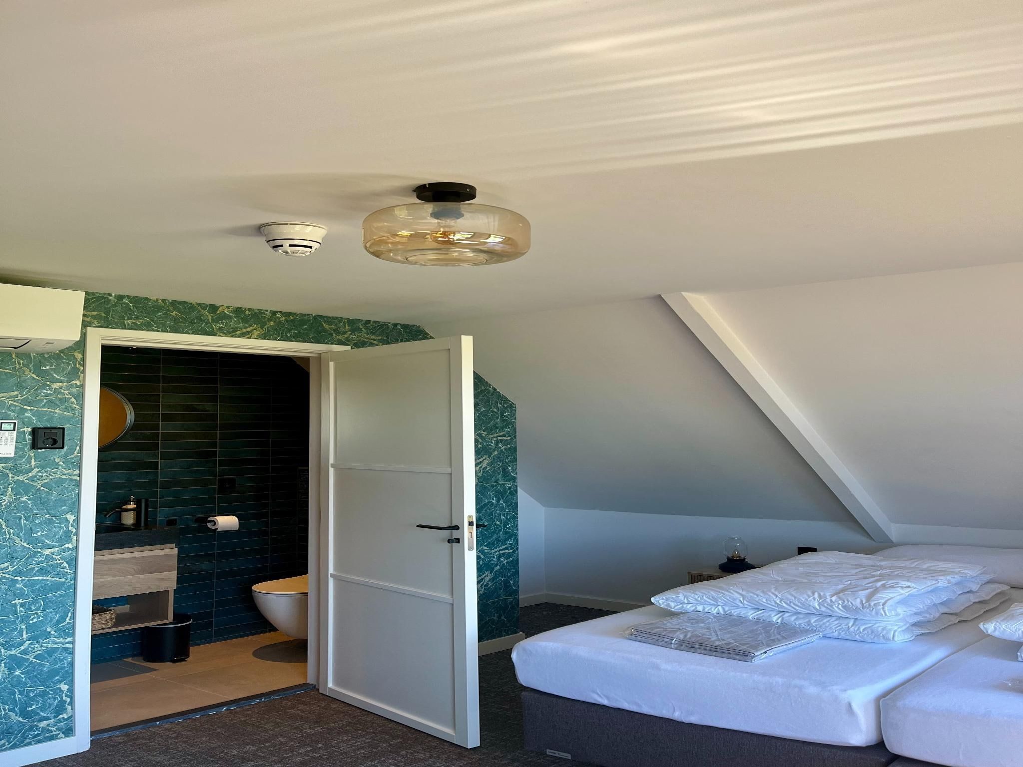 Een slaapkamer van Groepsaccommodatie met 10 luxe tweepersoons kamers in Scherpenzeel (FR)