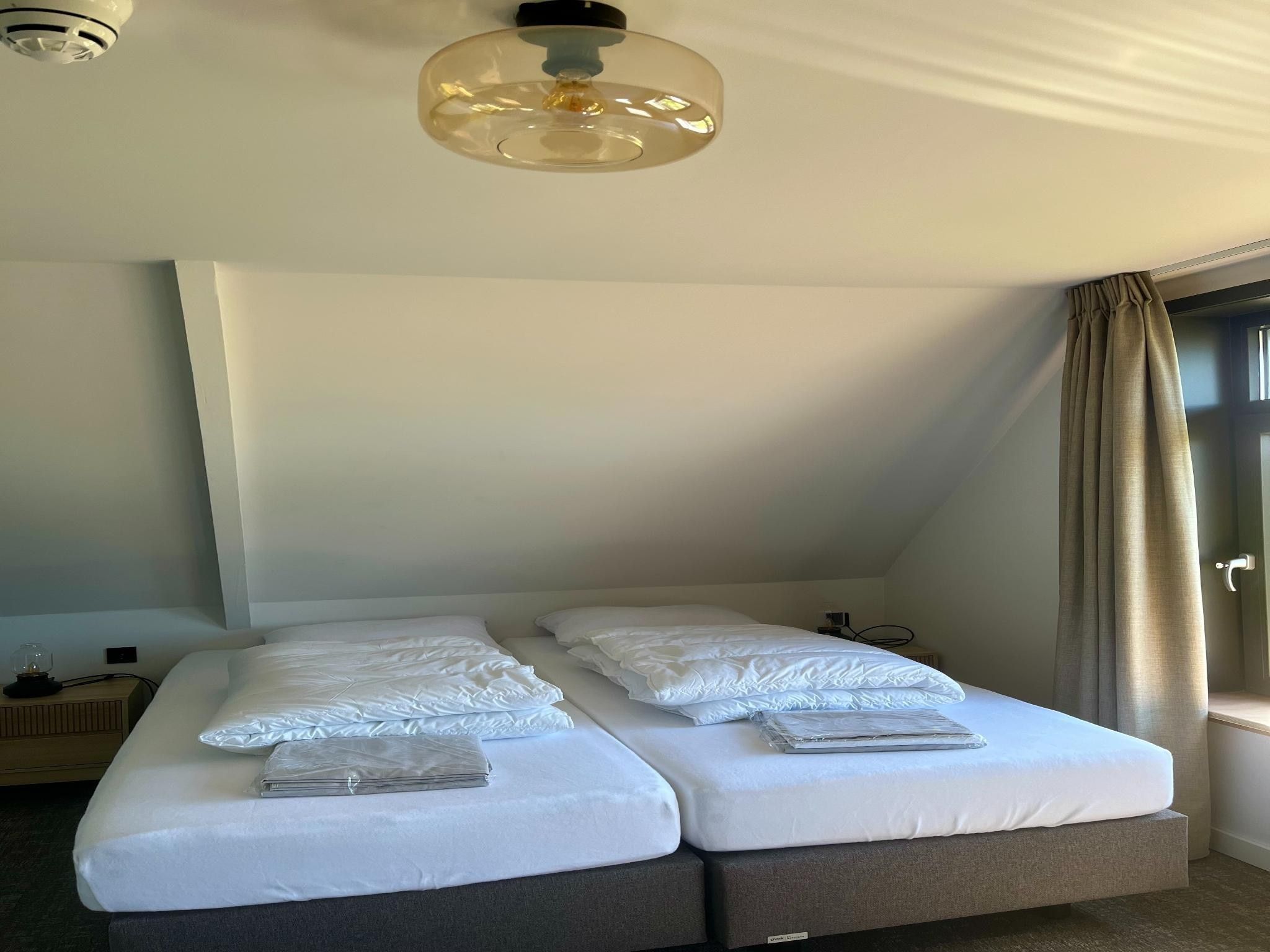 Een slaapkamer van Groepsaccommodatie met 10 luxe tweepersoons kamers in Scherpenzeel (FR)