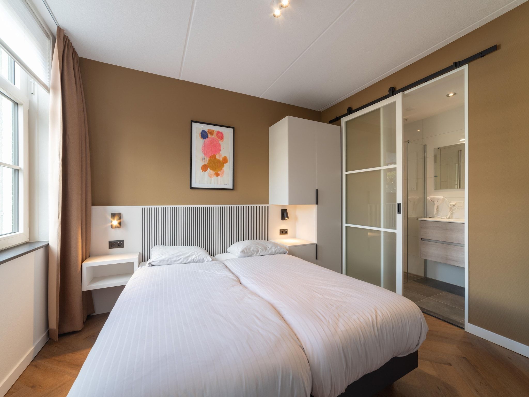 Een slaapkamer van Villa 12 - 12-persoons villa met buitenjacuzzi in Colijnsplaat