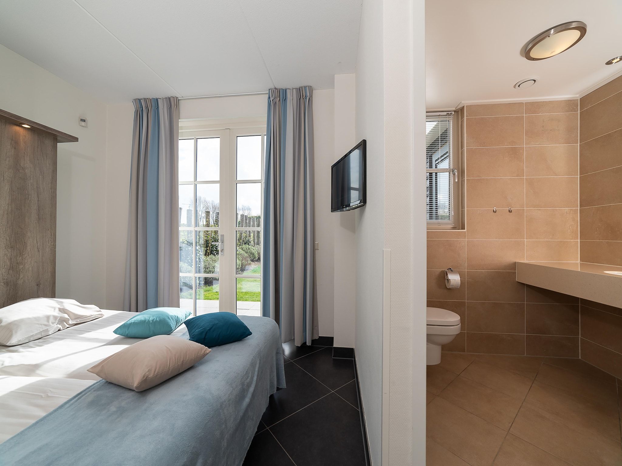 Een slaapkamer van Luxe Beveland met Zwembad in Colijnsplaat