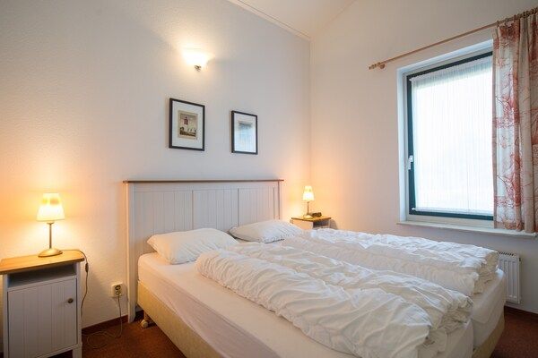 Slaapkamer - Ruime gerenoveerde gelijkvloerse bungalow in Hollum (4)