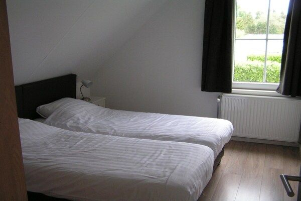 Slaapkamer - Ruime 10-persoonsvilla op rustig vakantiepark in Baarle-nassau (5)